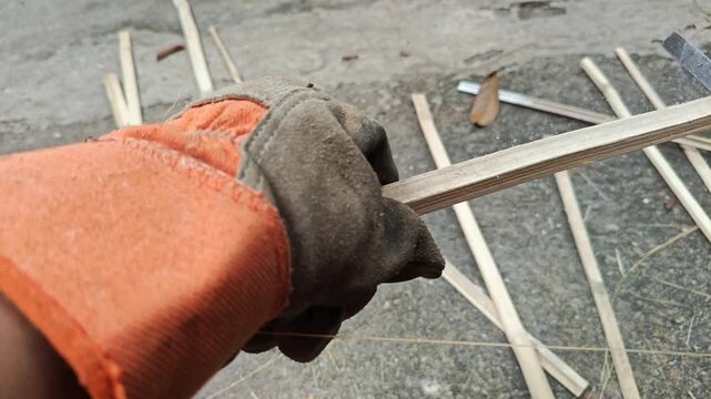 Gloved Hands Filing Bamboo Pole with Rasp File