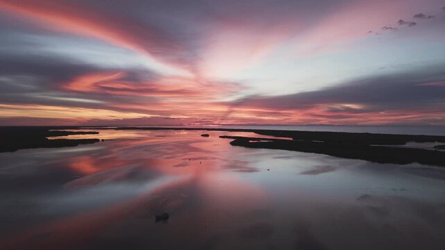 Vista a&eacute;rea del atardecer sobre el estero de R&iacute;o Lagartos con reflejos y embarcaciones, Yucat&aacute;n, M&eacute;xico. Reflejos del atardecer sobre el estero de R&iacute;o Lagartos.
