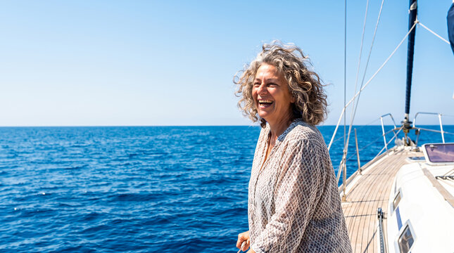 Woman laughing on sailboat deck in open ocean