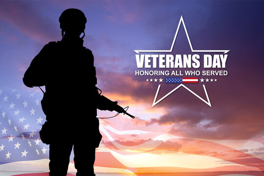 Silhouette of a soldier with USA flag against the sunset. Veterans Day concept