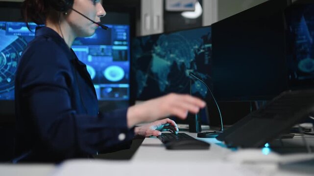 Female cybersecurity analyst working in a futuristic command center. She uses interactive screens and a headset to manage global data networks.