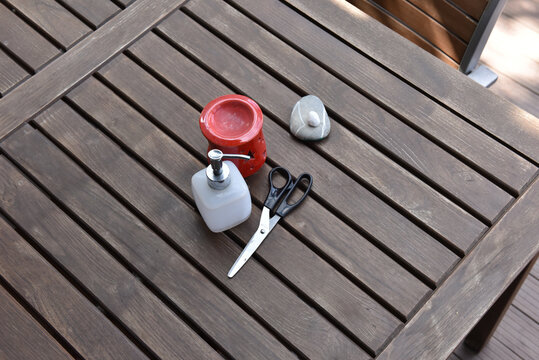 Soap dispenser and red tea light holder on a slatted wooden table