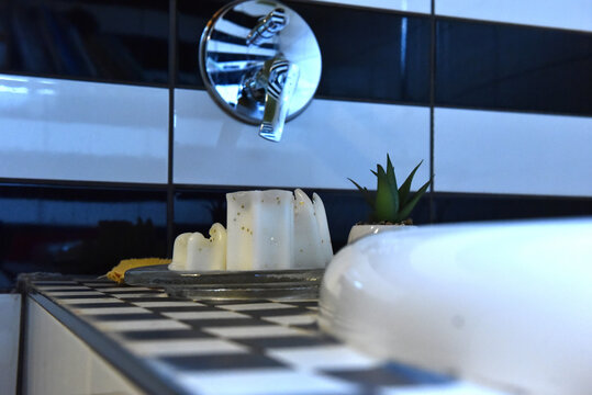Decorative snowflake candles and bath essentials on checkered bathroom tiles