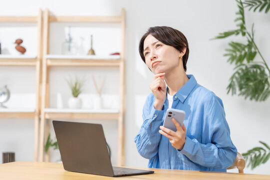 スマホを見て悩む女性