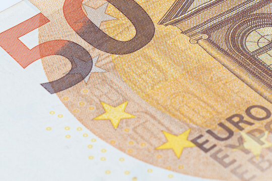 Macro close up of a 50 euro banknote showing detailed texture, stars and security features. European currency, finance, banking and economy concept.