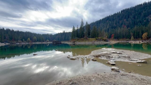 Autumn scenery at Lake Cauma in Flims, Switzerland, with its small island reflected in calm, mirror-like water beneath a cloudy sky, symbolizing tranquility, mindfulness and natural beauty.