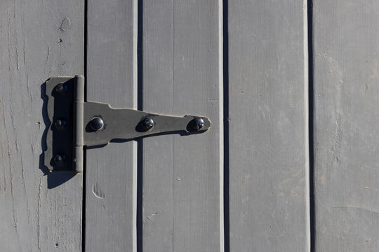 Gray wooden door with metal hinge hardware