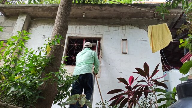Young Person Climbing Ladder with Broom to Clean Window