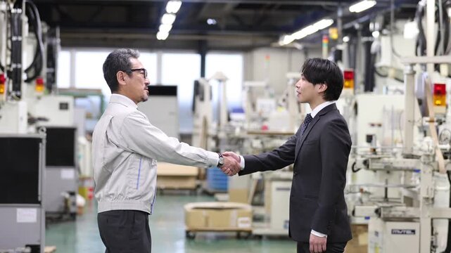 工場内で銀行担当者と握手を交わす製造業の経営者・企業融資契約の成立と資金調達