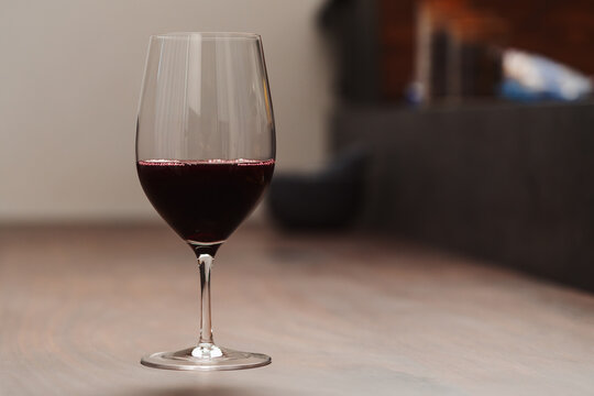 Red wine in thin wine glass on wood table