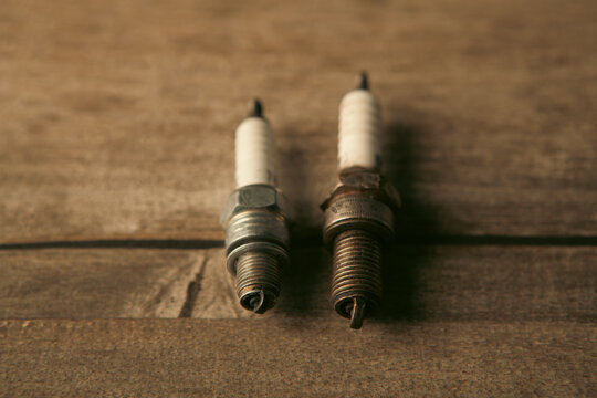 an old and a new spark plug on the table