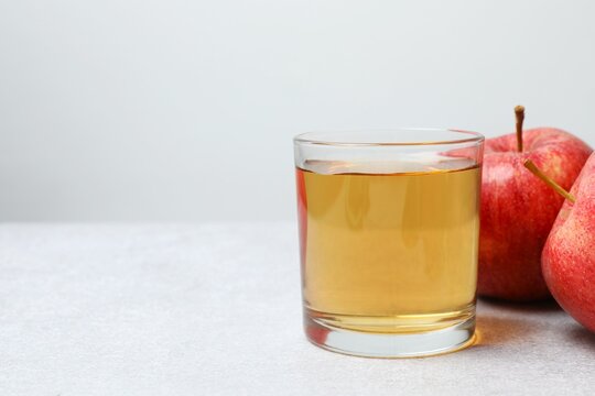 Glass of freshly squeezed apple juice on the table, copy space