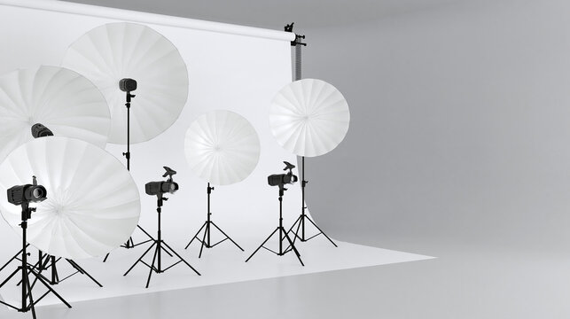 Professional photo studio lighting setup with white umbrella reflectors and flash strobes on black stands. Minimalist photography workspace with a clean white backdrop and gray floor. Copy space