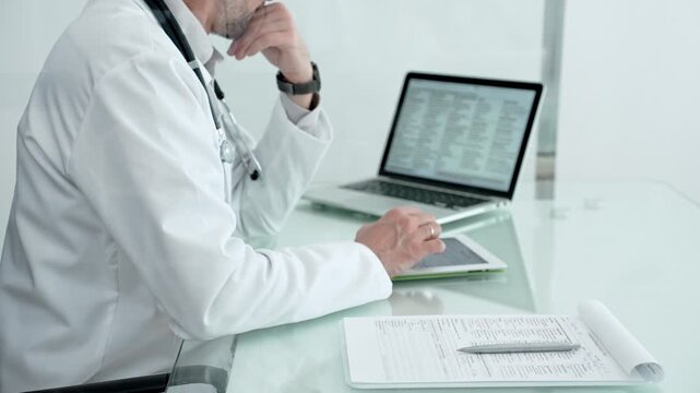Doctor engaging with a patient during a healthcare consultation. Inputting or reviewing patient data on a tablet device