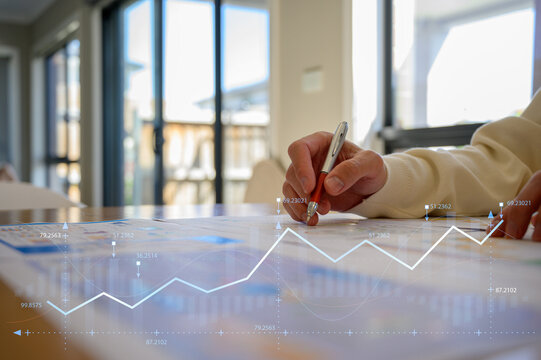 Businessman using pen and paper report while analyzing data at office, Financial analysis or business evaluation concept