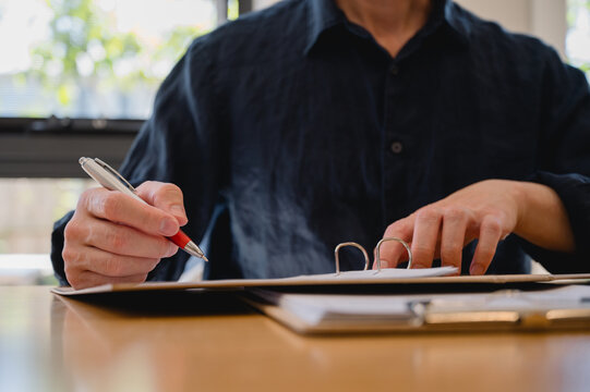 Businessman use pen review document and analysing report, utilizing intelligent management system to validate records and streamline final approvals, Digital document workflow and quality assurance