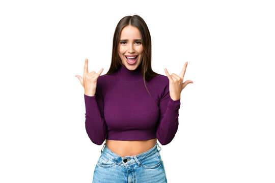Young beautiful woman over isolated chroma key background making horn gesture