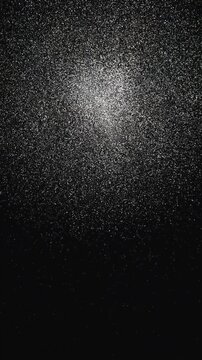 Vertical video: Forming from two bright speck clusters moving inward, cloud growing on black field