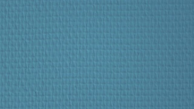 Textured turquoise blue painted wall with a raised basket weave pattern, full frame abstract background texture, French Riviera, France.
