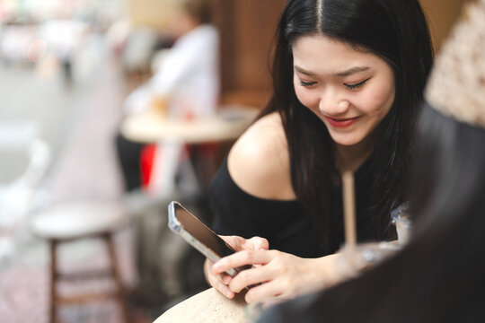 Enjoy two young asian woman gen z sisters using smartphone share travel moment on social media