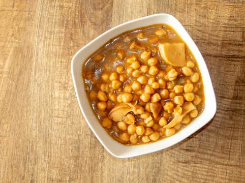 Primer plano de un plato de guiso de garbanzos, Madrid, Espa&ntilde;a. Una receta espa&ntilde;ola de guiso con setas porcini, que incluye garbanzos y trozos de seta visibles en la superficie del plato.
