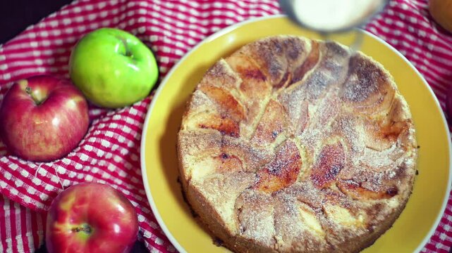 Sieve dusting powdered sugar apple cake. Top view baked pie red green apples.
