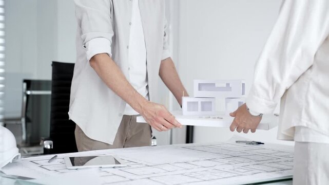 Architects and clients shaking hands in office, establishing a new construction project partnership, securing a successful business deal, and building trust in design
