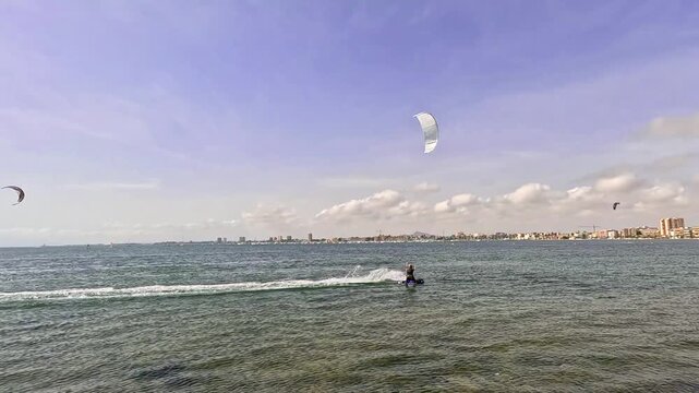 Man kitesurfing with a white kite on Mar Menor in Murcia Spain