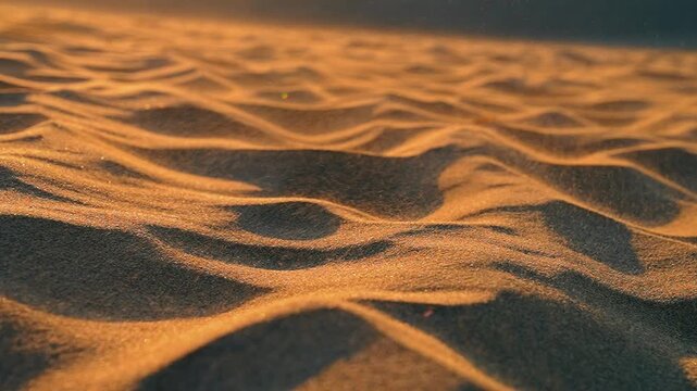 Slow motion of wind scattering sand grains across the dunes.