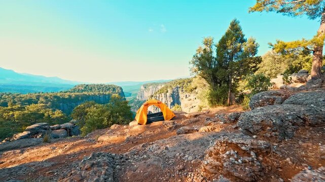 Tazi Canyon in Antalya features a yellow tent perched on the summit, overlooking breathtaking cliffs and a spectacular natural landscape.