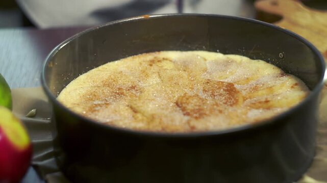 Sugar sprinkled pie batter springform pan close up. Hands removing cake tin.