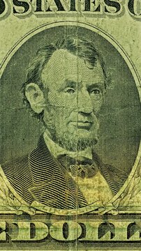 Five Dollar Bill Lincoln Portrait Under Scanning Light. Lincoln portrait on five dollar bill glows under moving scanning light. Macro currency detail reveals engraved lines.