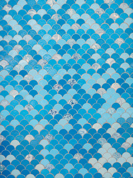 Wall covered with blue and white fish scale mosaic tiles