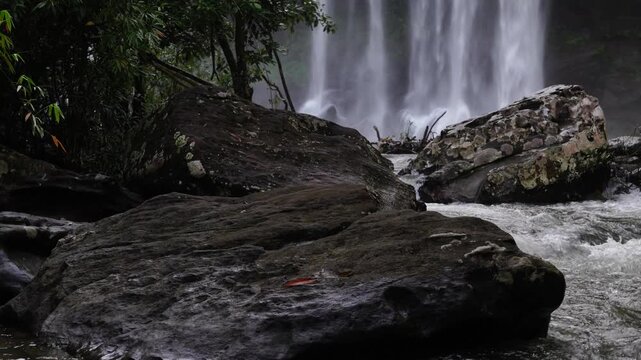 Dark Wet Boulders Below a Powerful Waterfall