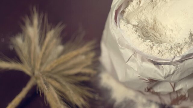 Paper bag white flour close up pan. Wheat ears rolling pin wooden spoon table.