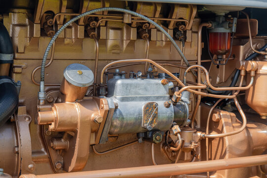 Engine bay of a restored 1950s agricultural tractor showing the fuel injection pump, fuel lines, cylinder head and ancillary components