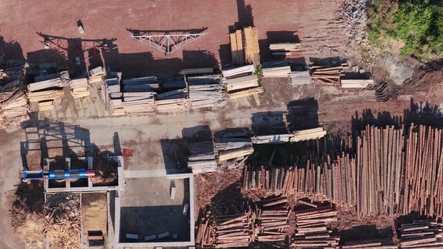 Aerial top view of sawmill processing wood logs and lumber stacks