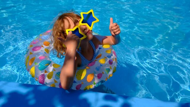 Children are swimming and playing in the pool. Selective focus.