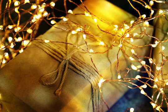 Christmas gift with glowing fairy lights and rustic twine