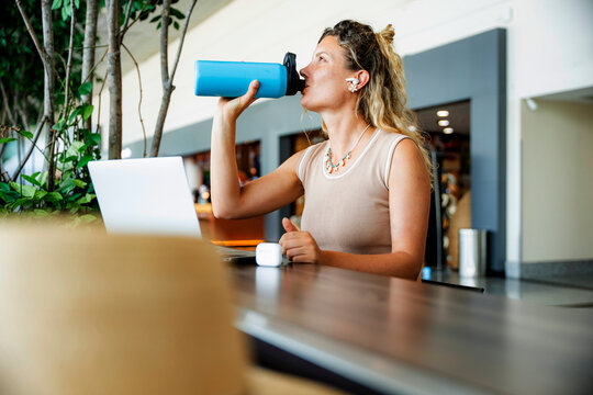 Digital nomad woman drink water while working remotely
