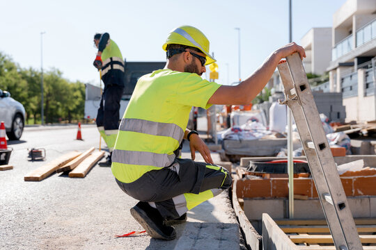 Utility worker repair water leak beside residential street