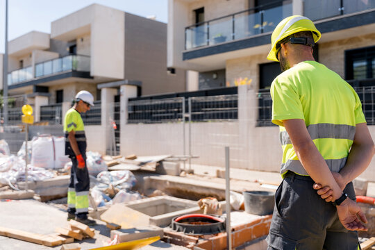 Construction workers inspect street maintenance work site