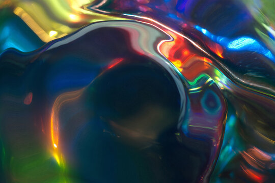 Iridescent liquid metal surface with colorful light reflections