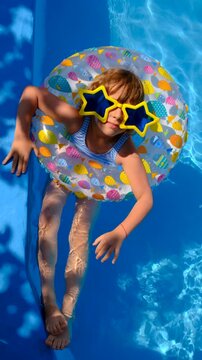 Children are swimming and playing in the pool. Selective focus.