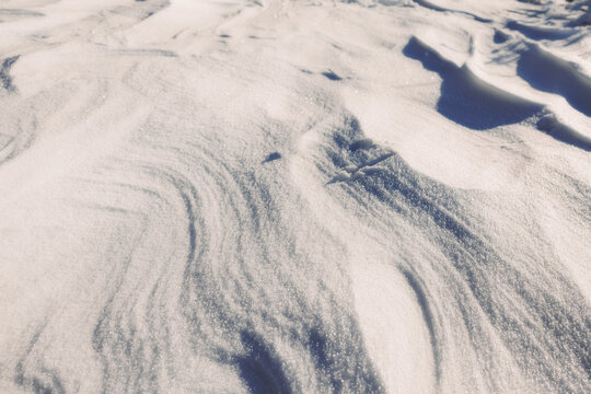 Sunlit snow texture with soft winter shadows and sparkle