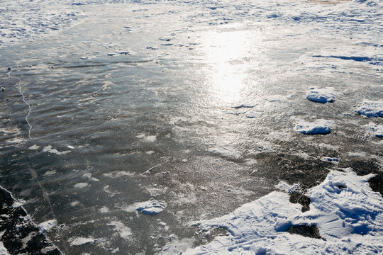 Sunlit snow and ice texture on a frozen winter surface