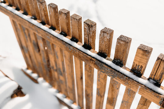 Snow-covered wooden fence detail in warm winter light
