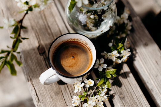 Coffee cups with spring blossoms on rustic wooden table