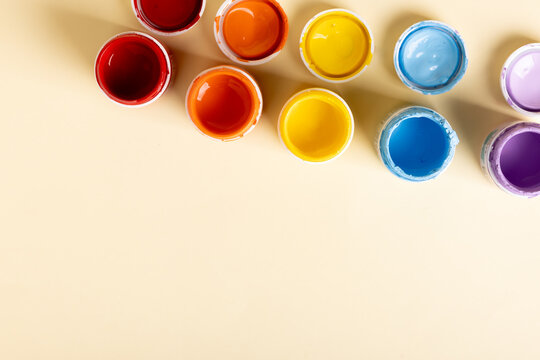 Colorful paint pot arrangement on a pastel background