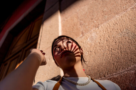 Mexican teenager in urban sunlight with dramatic shadow